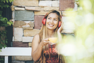 Happy young woman relax with listen favorite music at cafe