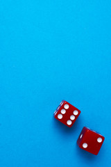 Red gaming dices on blue background. Flat lay, place for text. Game concept