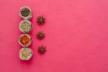 Fototapeta na wymiar spices on a plate and jars on a violet background