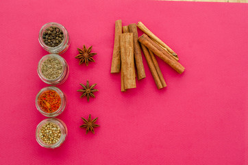 spices on a plate and jars on a violet background