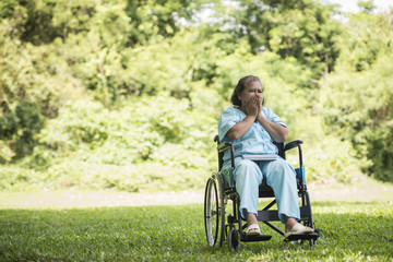 Fototapeta na wymiar Lonely elderly woman sitting sad feeling on wheelchair at garden in hospital