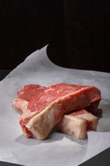 Raw beef striploin steak. Two strip loin steaks on dark. Fresh meat. Close up.