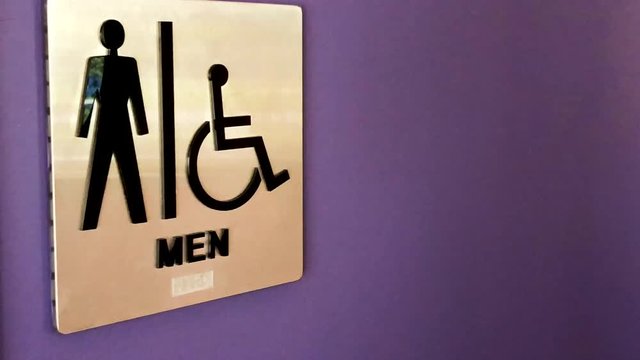 Men's restroom sign on purple wall in office environment.