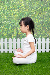 Asian Chinese little girl practicing yoga pose on a mat