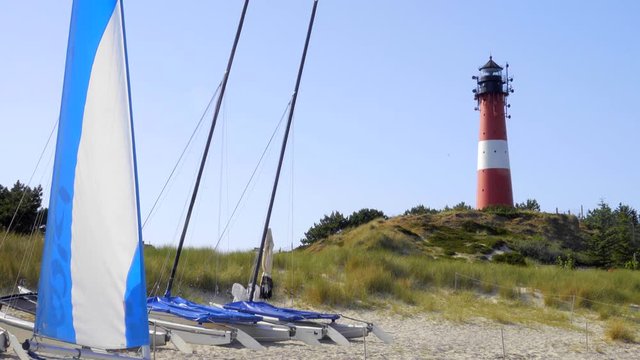 Leuchtturm H&ouml;rnum Sylt mit D&uuml;nen Landschaft und Surfschule  am Strand
