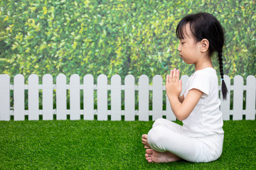 Asian Chinese little girl practicing yoga pose on a mat