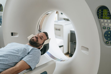 Patient Lying on the CT Scanner Bed - obrazy, fototapety, plakaty
