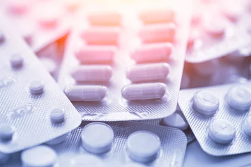 Poster Verschillende medicijnen: tabletten, pillen in blisterverpakking, medicijnen medicijnen, macro, selectieve focus, kopieerruimte, blauw getint © DedMityay