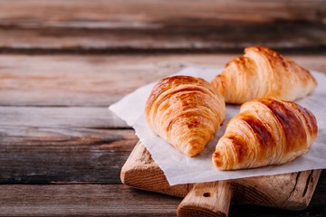Homemade baked croissants on wooden rustic background
