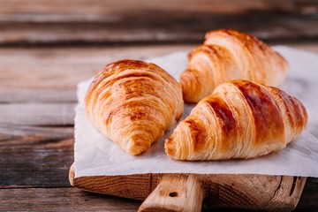 Homemade baked croissants on wooden rustic background
