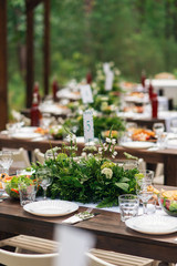 Elegant wedding table arrangement, floral decoration, restaurant. Wedding table setup. Wedding in the forest