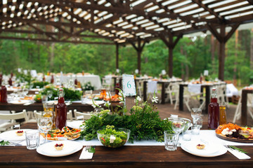 Elegant wedding table arrangement, floral decoration, restaurant. Wedding table setup. Wedding in the forest