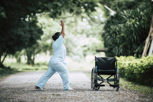 Physical therapy senior woman with wheelchair in the park - Powered by Adobe