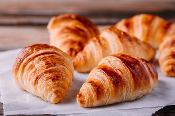 Homemade baked croissants on wooden rustic background