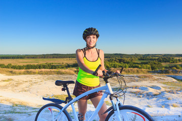 Fototapeta premium Young beautiful woman with a sport bike, soft focus background