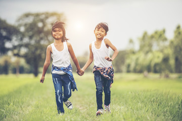 Two little girls hand holding together having fun in the park