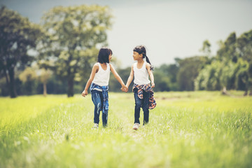 Two little girls hand holding together having fun in the park