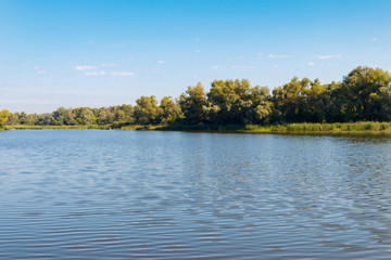 Summer landscape with beautiful river, green trees and blue sky