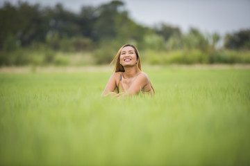 Young woman sitting feel good in grass field.