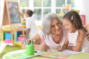 Fototapeta premium Senior woman with little schoolgirl at class