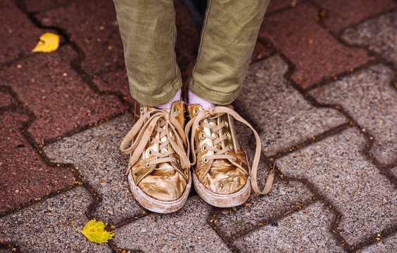 Worn Out Worn Sneakers On The Feet Of A Teenager On The Street, Paving Slabs