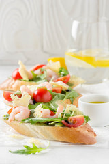 Bruschetta with arugula, shrimp, cherry tomatoes and balsamic vinegar. Three  tasty open sandwiches for lunch