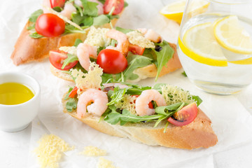 Bruschetta with arugula, shrimp, cherry tomatoes and balsamic vinegar. Three  tasty open sandwiches for lunch