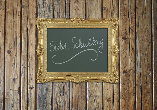 Old antique gold frame on textured wooden wall