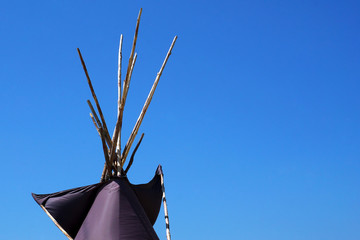 Top of Indian wigwam lodge or teepee against blue sky background. travel concept. copyspace © MichaelPervak