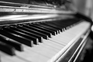 The black piano, selective focus. Closeup of antique piano keys and wood grain