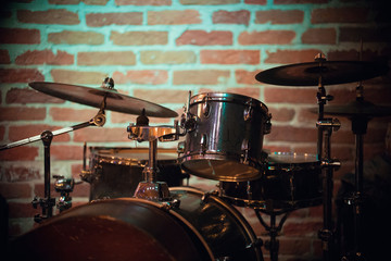 Fototapeta na wymiar A beautiful drum stands against a brick wall in a jazz bar