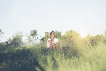 Tourist woman with a backpack sitting in the grass