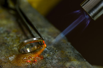 Profession jeweler. Craft jewelery making  in the jeweler's workshop. Soldering process. Closeup.