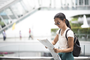 Female tourist with city map looking destination