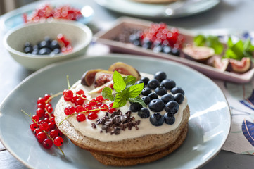 Pancakes oder Pfannkuchen mit Yoghurt und Beeren frisch angerichtet