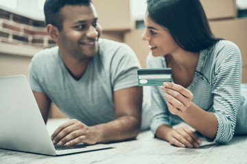 Young Smiling Couple Shopping Online on Laptop