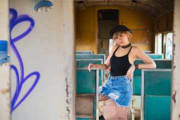 Portrait of beautiful asian woman new look with short hairs on old train,Black dress with skirt jeans outdoor,thailand people