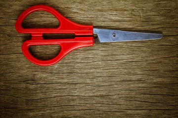 red scissors on old wood background.