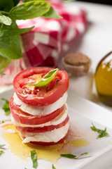 Caprese salad with italian mozzarella cheese on white plate