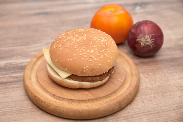 Simple cheeseburger on wooden plate