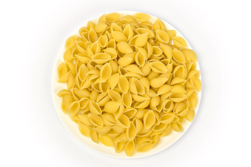 Pasta in the form of seashells on a plate on a white background