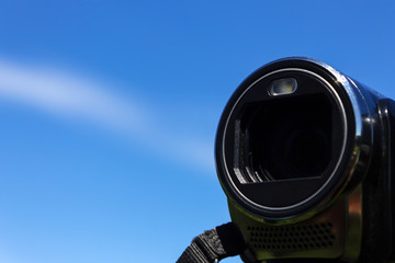 Lens camcorder on blue sky background