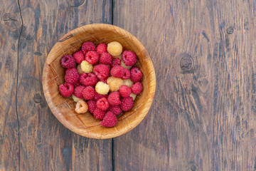 Big Pile of Fresh Raspberries in the wooden Bowl