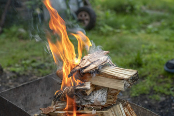Flame of wood burning in brazier during the preparation for cooking BBQ.