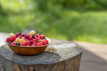 Big Pile of Fresh Raspberries in the wooden Bowl