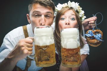 Oktoberfest, Frau und mann in Bayerischer Tracht mit Bier Krügen 