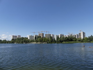 Obraz premium A lake against the background of houses under construction. Skys