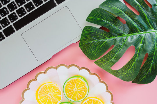 Computer Laptop With Green Leaf Palm And Lemon Slice On Pink Color Background For Food Planning Concept. Flat Lay And Top View Image.