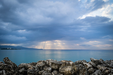 Fototapeta na wymiar Sunburst through the clouds as sunset approaches in Montego Bay, Jamaica.