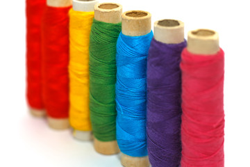 Colored thread coils with middle coil focused on white background